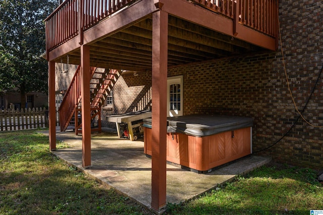 view of patio / terrace featuring a hot tub and a deck