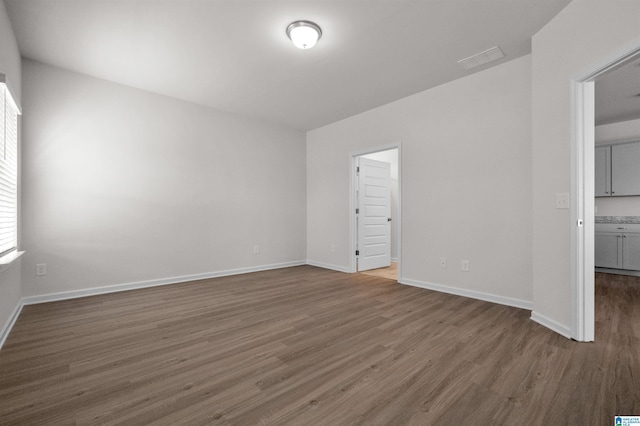 empty room with dark hardwood / wood-style flooring