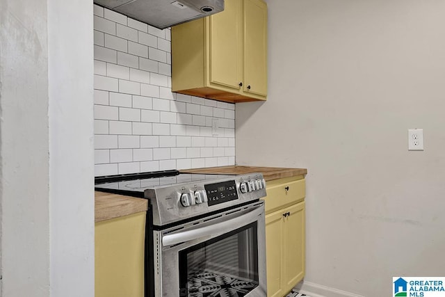 kitchen featuring stainless steel electric stove, butcher block counters, tasteful backsplash, and exhaust hood