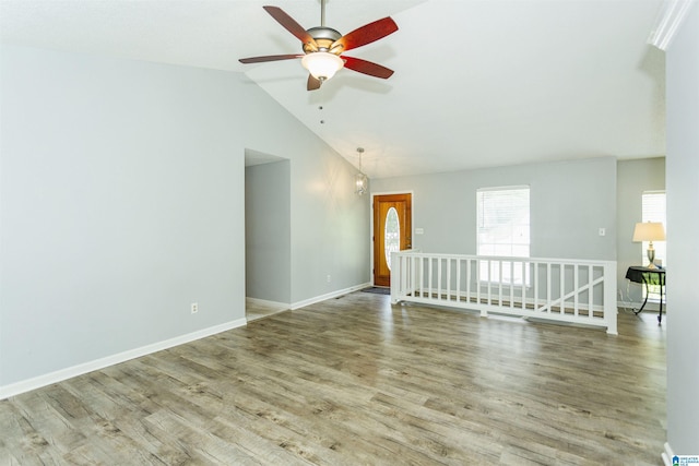 empty room featuring hardwood / wood-style flooring, ceiling fan, and vaulted ceiling