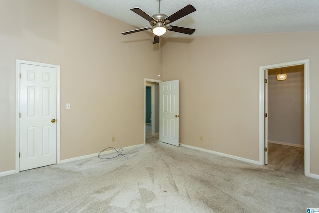 unfurnished bedroom featuring light carpet, a textured ceiling, high vaulted ceiling, and ceiling fan