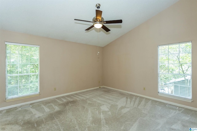 carpeted spare room featuring ceiling fan, a healthy amount of sunlight, and vaulted ceiling