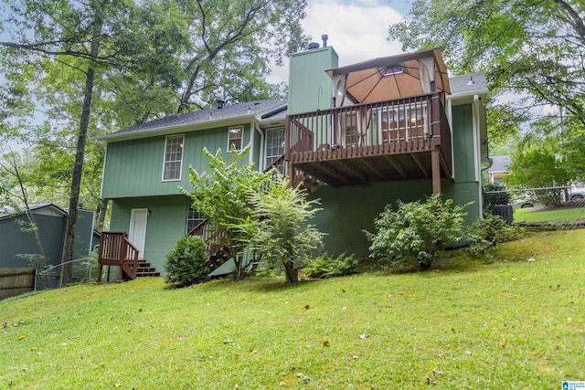 back of property featuring a lawn and a wooden deck