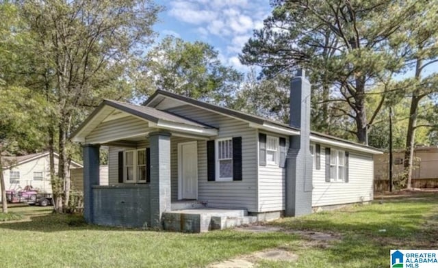 bungalow with a chimney and a front yard