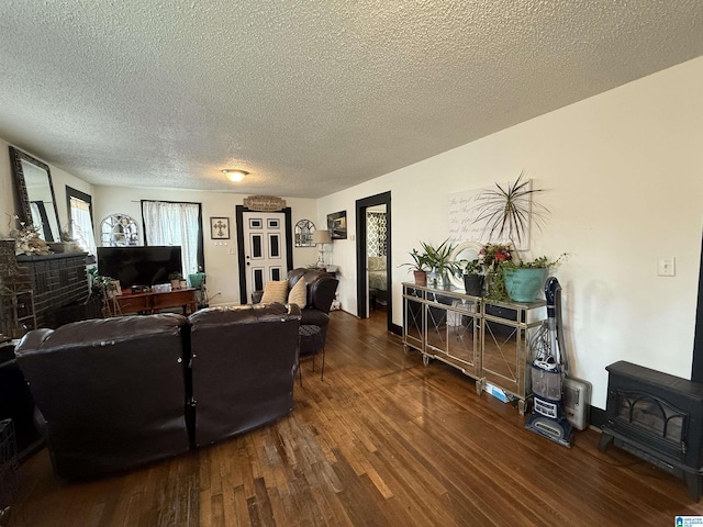 living room featuring a textured ceiling, wood finished floors, and a wood stove