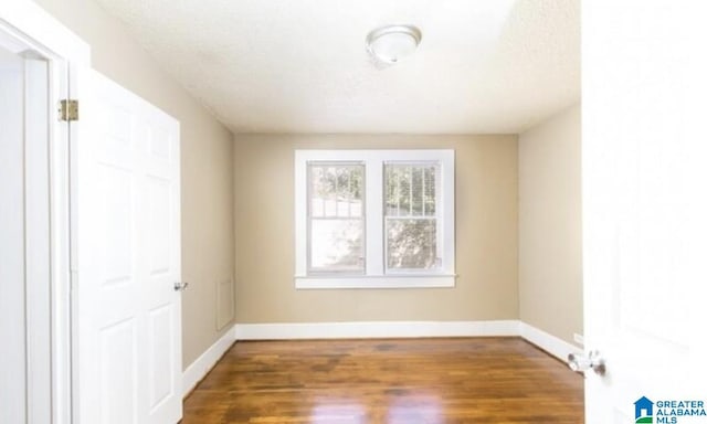 unfurnished room with hardwood / wood-style floors and a textured ceiling