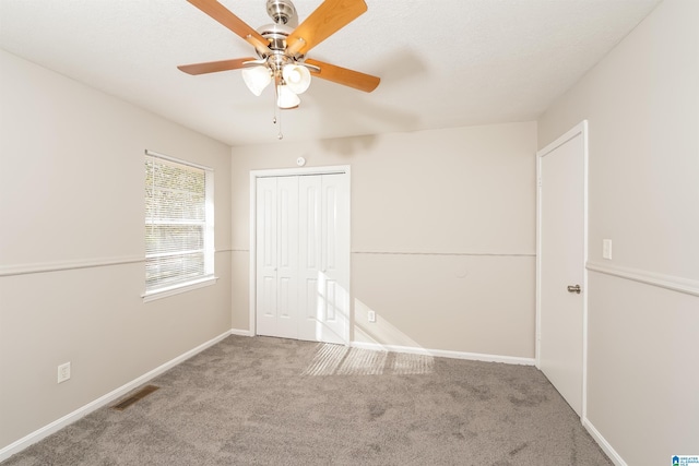 unfurnished bedroom featuring ceiling fan, carpet floors, and a closet