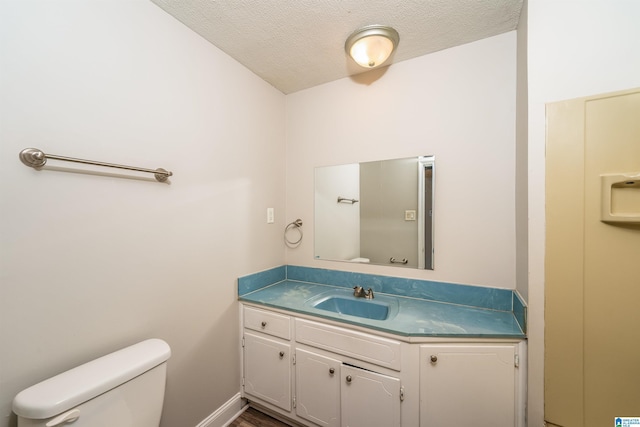 bathroom featuring a textured ceiling, vanity, toilet, and wood-type flooring