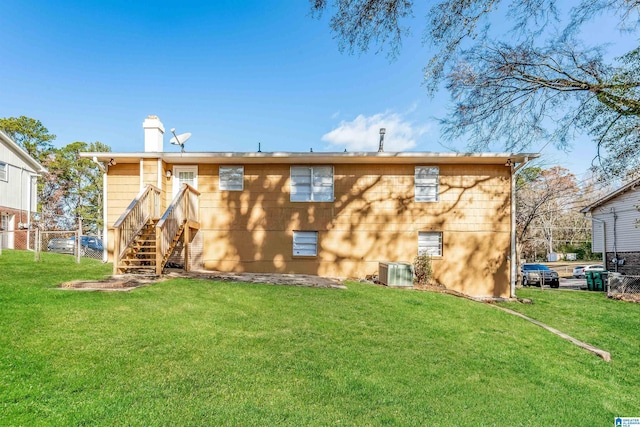 rear view of house with a lawn and central AC