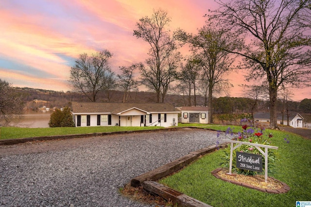 ranch-style home featuring an outbuilding and a lawn