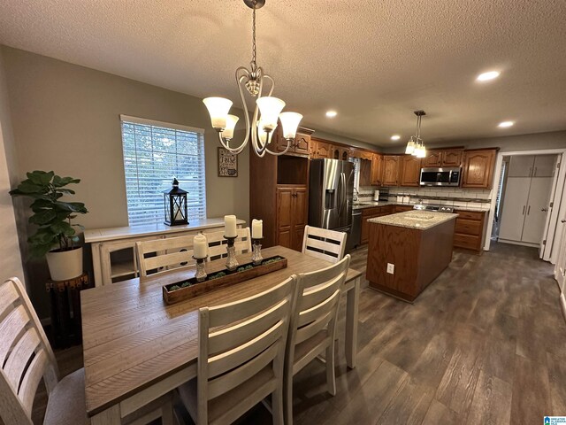 dining area with a textured ceiling, a chandelier, and dark hardwood / wood-style floors