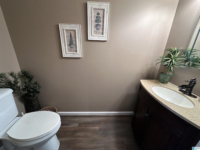 bathroom featuring hardwood / wood-style flooring, vanity, and toilet