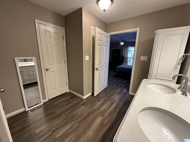 bathroom featuring hardwood / wood-style floors, vanity, and a textured ceiling