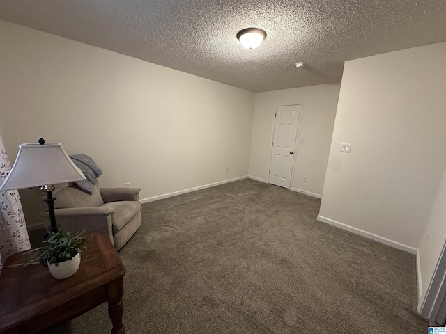 unfurnished room featuring dark colored carpet and a textured ceiling