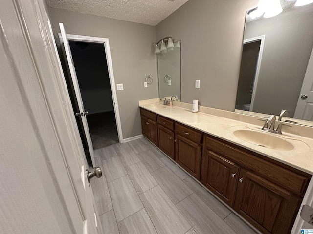 bathroom with vanity, toilet, and a textured ceiling