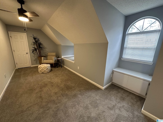 unfurnished room featuring a textured ceiling, ceiling fan, carpet, and lofted ceiling