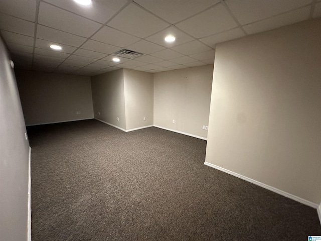 carpeted spare room with a drop ceiling