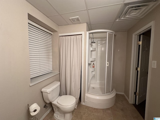 bathroom featuring tile patterned flooring, a paneled ceiling, toilet, and a shower with shower door