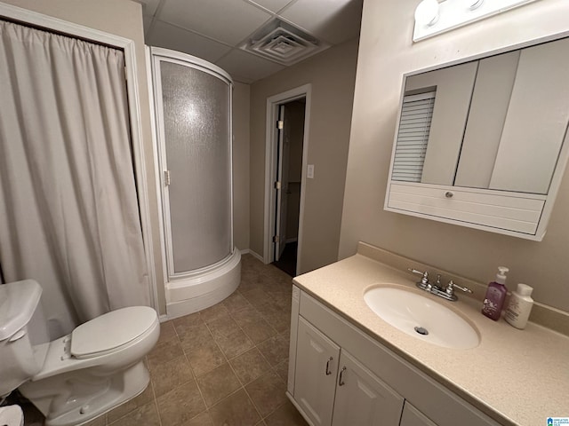 bathroom featuring walk in shower, tile patterned floors, toilet, a paneled ceiling, and vanity