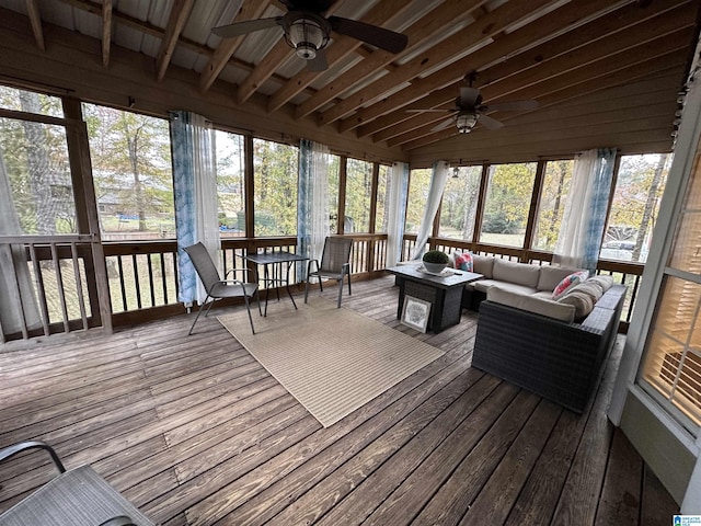 sunroom / solarium featuring beam ceiling and ceiling fan