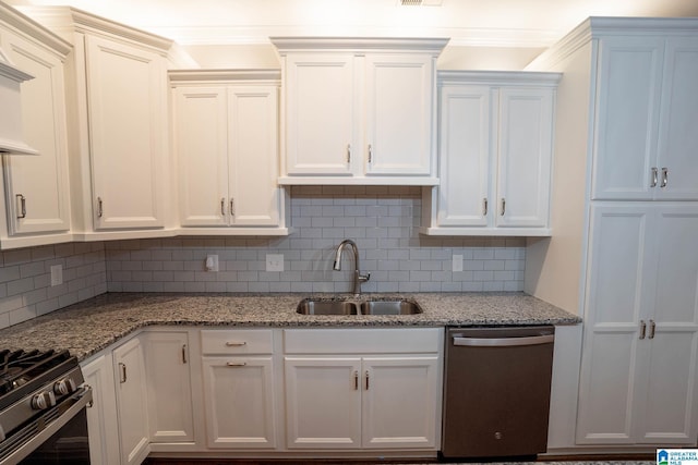 kitchen with sink, decorative backsplash, light stone countertops, appliances with stainless steel finishes, and white cabinetry