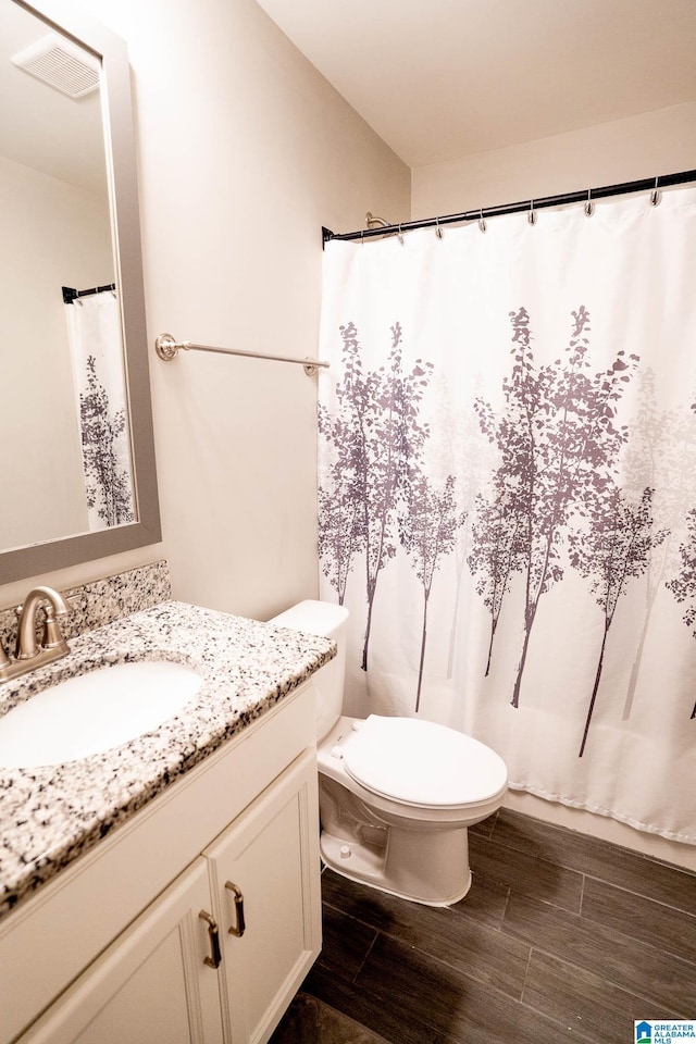 bathroom featuring hardwood / wood-style floors, vanity, and toilet