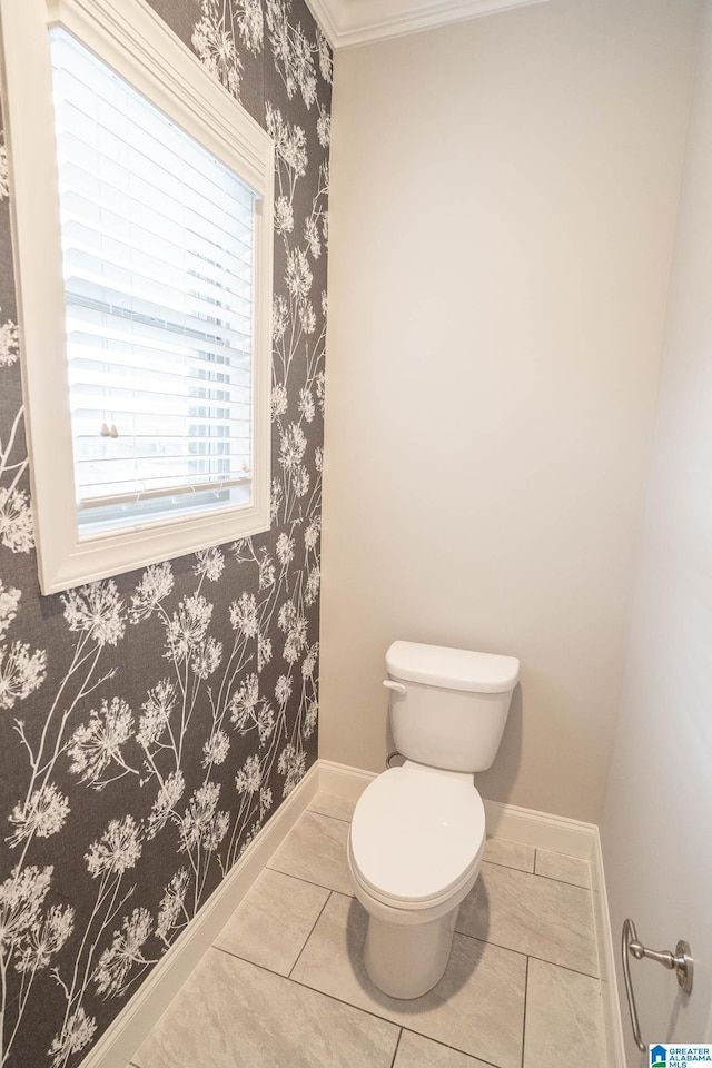 bathroom with tile patterned floors, toilet, and crown molding