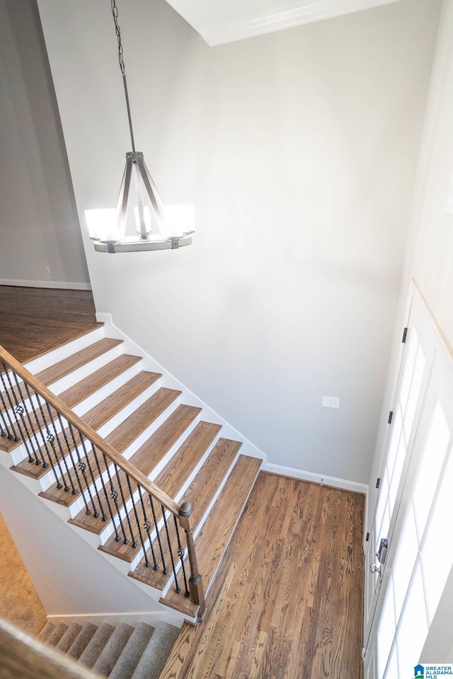 stairway with a chandelier and hardwood / wood-style floors