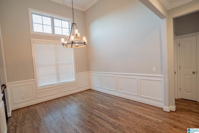 unfurnished room with crown molding, an inviting chandelier, and hardwood / wood-style flooring