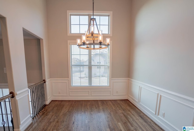 spare room featuring dark hardwood / wood-style flooring and a notable chandelier