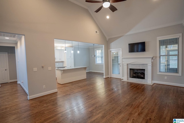 unfurnished living room featuring a fireplace, dark hardwood / wood-style flooring, ceiling fan, and crown molding