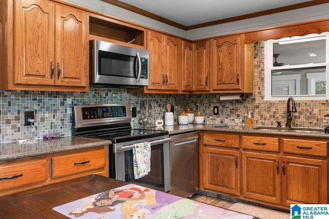 kitchen with decorative backsplash, crown molding, sink, and stainless steel appliances