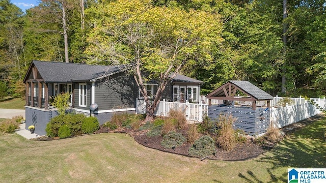 view of front of house with a sunroom and a front lawn