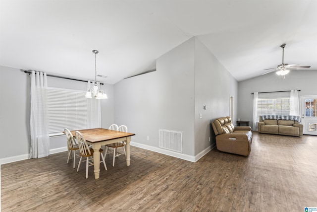 dining room with wood-type flooring, ceiling fan with notable chandelier, and lofted ceiling