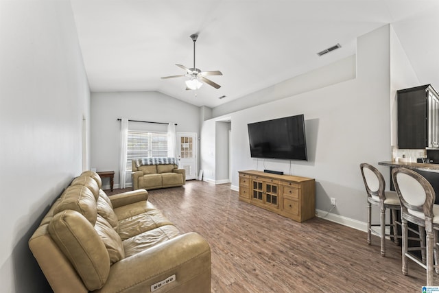 living room with ceiling fan, lofted ceiling, and dark wood-type flooring