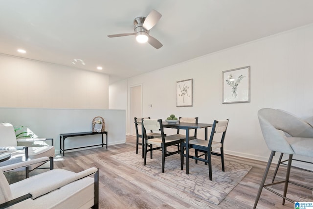 dining area with light wood-type flooring, ceiling fan, and crown molding