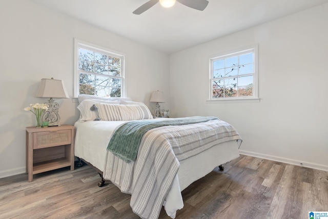 bedroom with multiple windows, ceiling fan, and hardwood / wood-style flooring