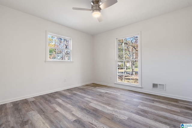 spare room featuring hardwood / wood-style floors, ceiling fan, and a wealth of natural light