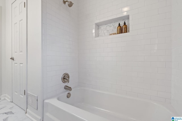 bathroom featuring tiled shower / bath