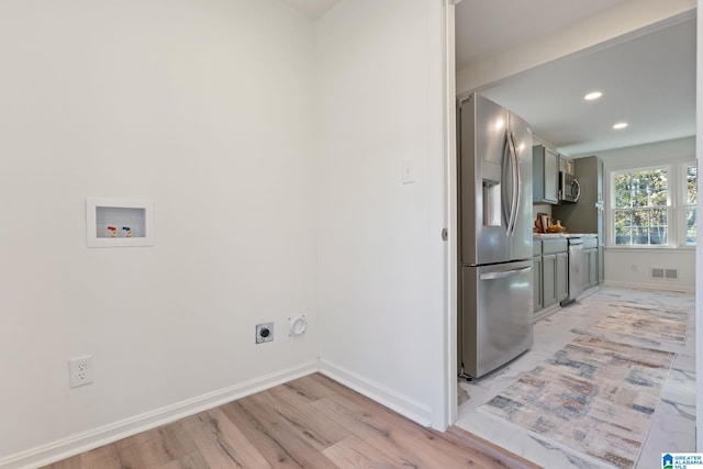 laundry area with washer hookup, gas dryer hookup, light wood-type flooring, and hookup for an electric dryer