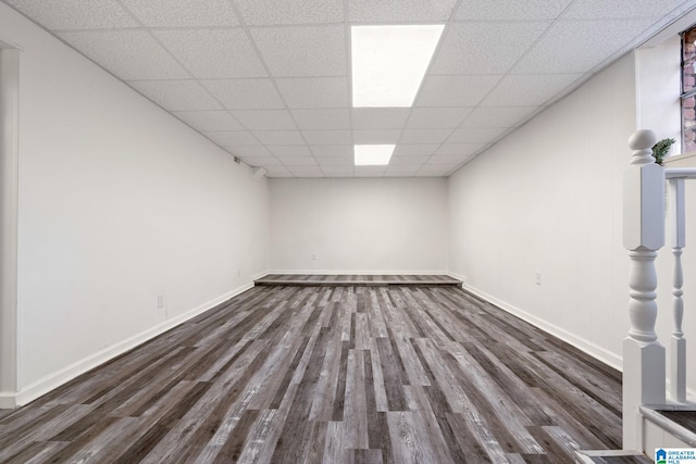 unfurnished room with dark hardwood / wood-style flooring and a paneled ceiling