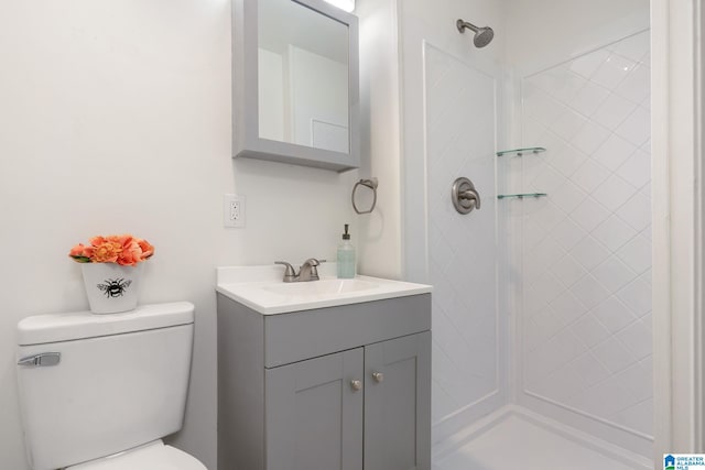 bathroom featuring tiled shower, vanity, and toilet