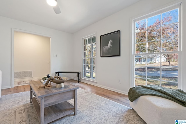 living room featuring light wood-type flooring and ceiling fan