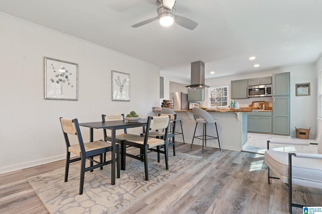 dining room with light hardwood / wood-style flooring, ceiling fan, and ornamental molding