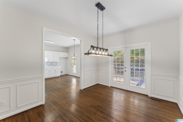 unfurnished dining area featuring french doors, dark hardwood / wood-style floors, a wealth of natural light, and crown molding