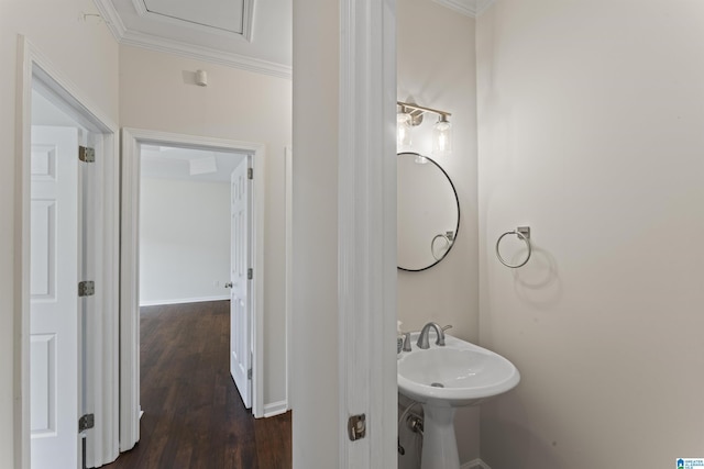 bathroom featuring hardwood / wood-style flooring, ornamental molding, and sink