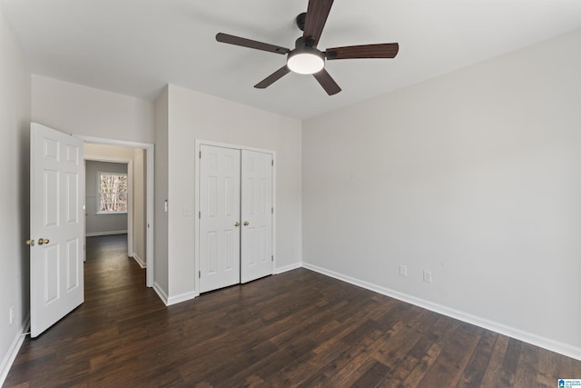 unfurnished bedroom with ceiling fan, a closet, and dark wood-type flooring