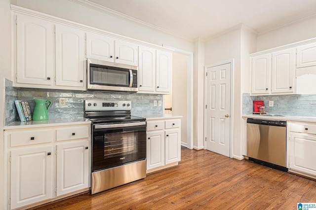 169 Glen Abbey Way, Alabaster, AL 35007 - kitchen featuring stainless steel appliances, decorative backsplash, white cabinetry, and crown molding