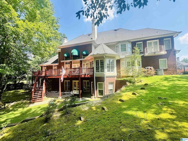 back of house featuring cooling unit, a wooden deck, and a lawn