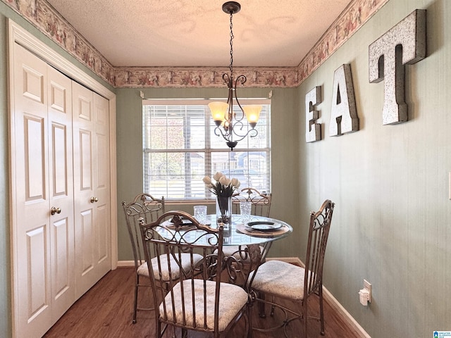 dining space featuring a chandelier, hardwood / wood-style floors, and a textured ceiling